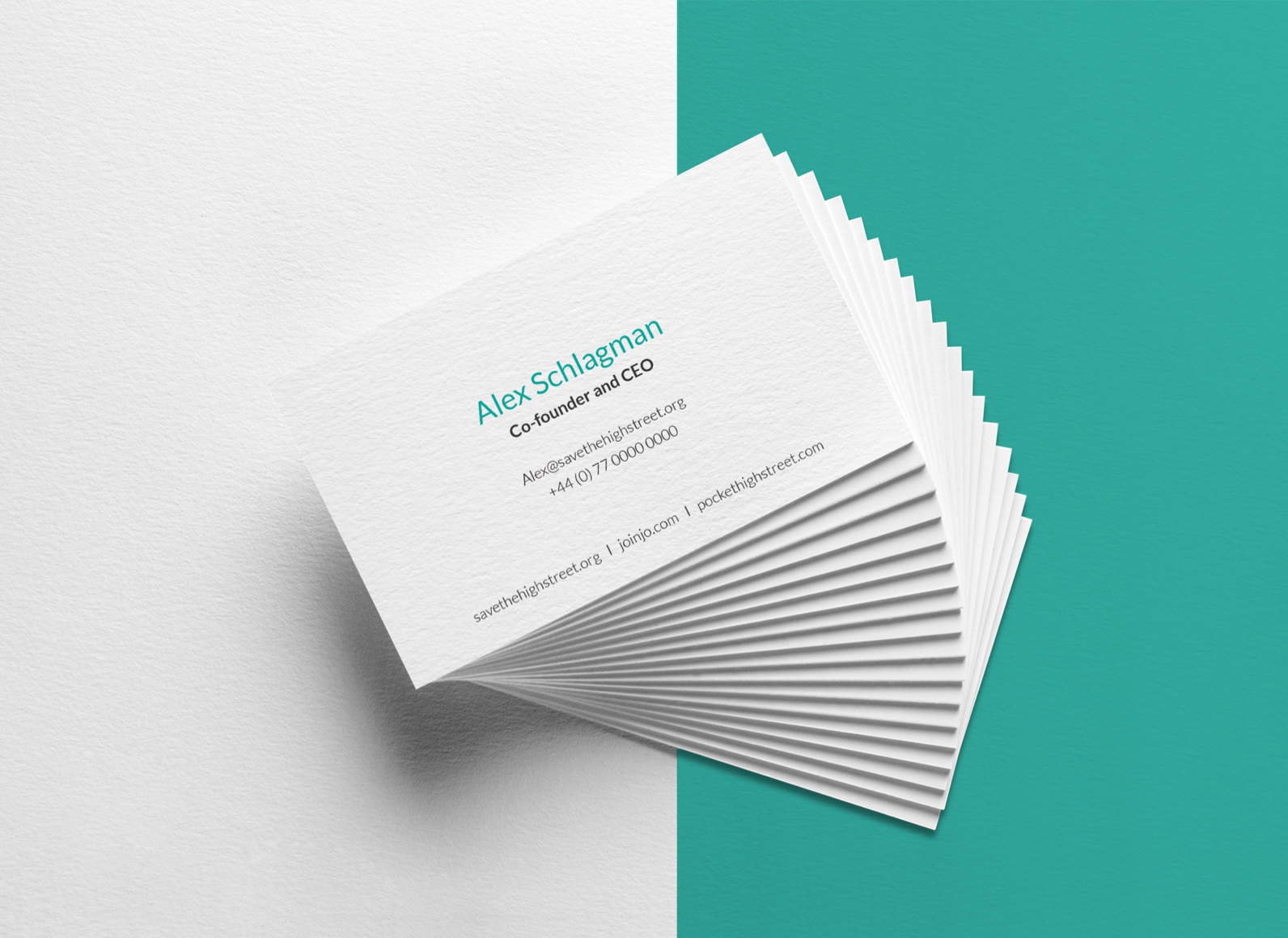 A stack of business cards on a white and teal colorsurface